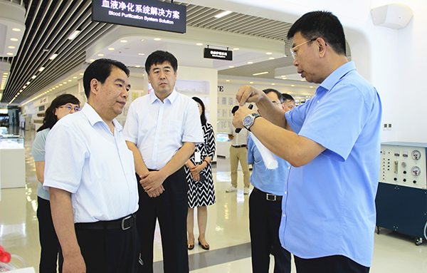 威高集团董事长张华威向调研组介绍企业自主研发产品